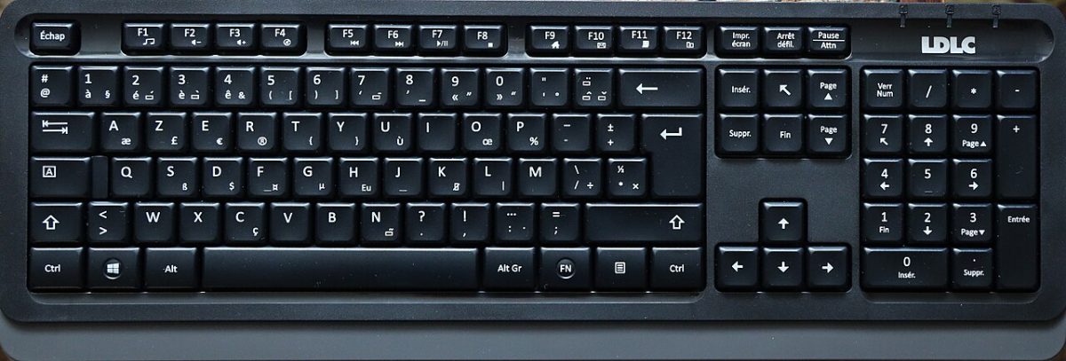 Primo piano sui tasti di una tastiera AZERTY che illustra la ripartizione delle lettere tra le due mani
