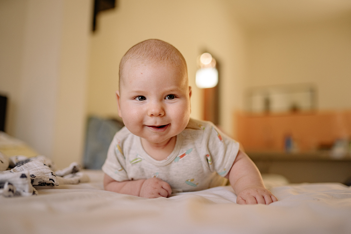 Four-month-old baby developing motor cognitive and social skills during supervised playtime