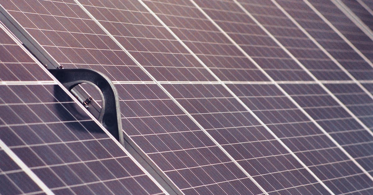 Bla fotovoltaiske solcellepaneler pa et tak i moderne teknologisk miljo som reflekterer sollys