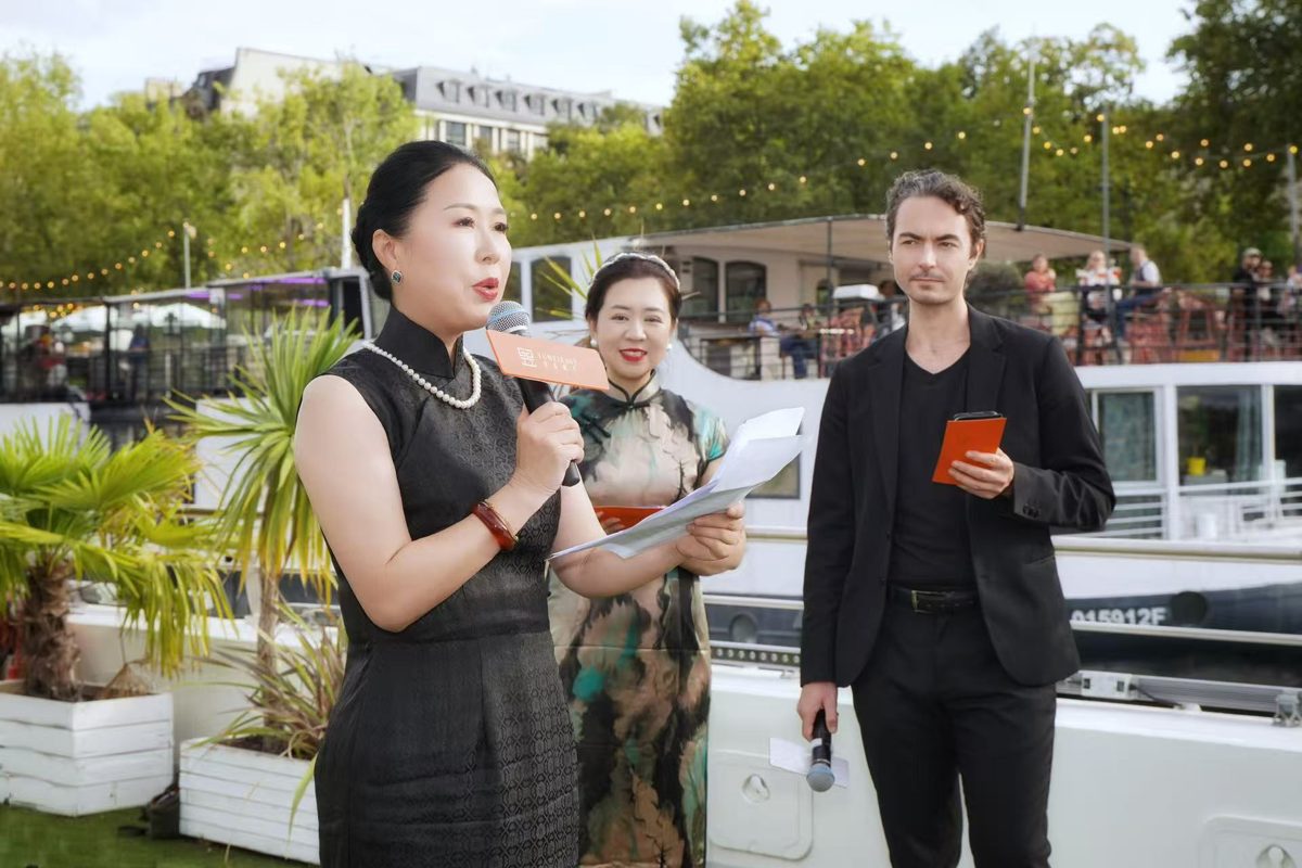 Speaking into a microphone during the YuMei East event aboard a boat on the Seine in Paris